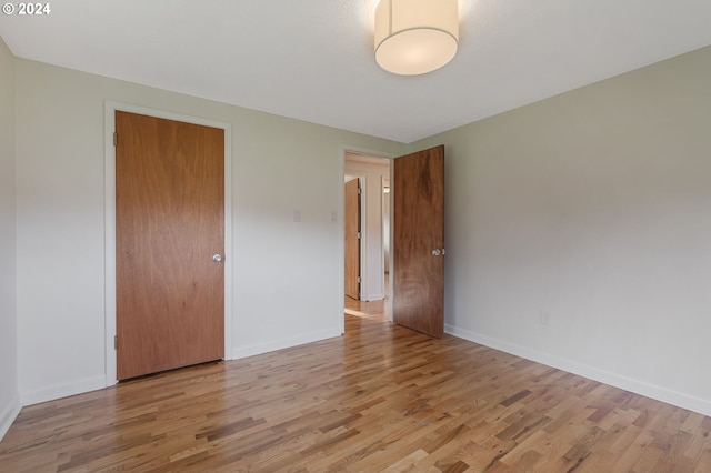 unfurnished bedroom with light hardwood / wood-style floors and a closet