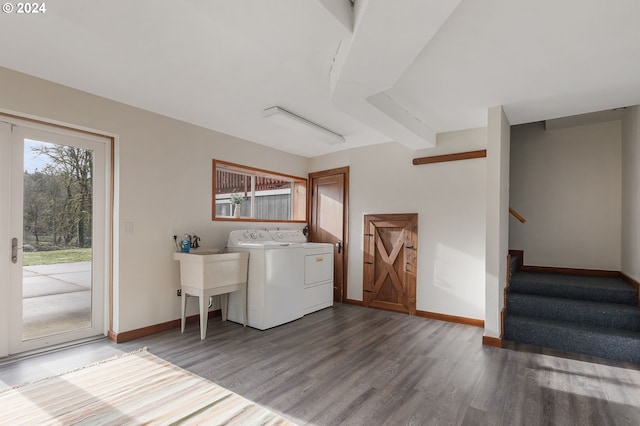 laundry area with hardwood / wood-style flooring, washing machine and dryer, and sink