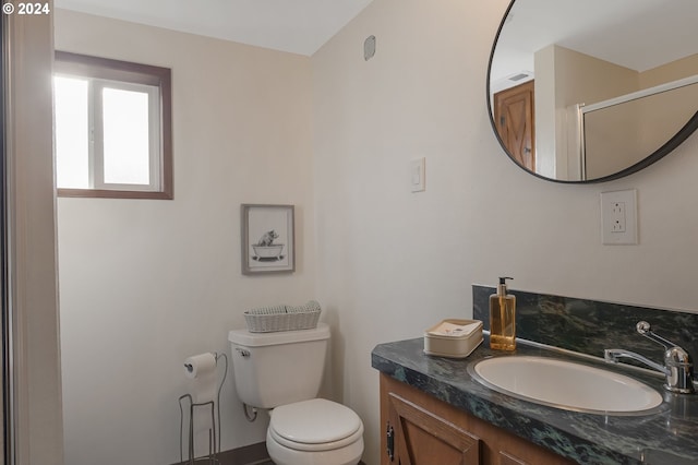 bathroom with vanity, a shower with shower door, and toilet