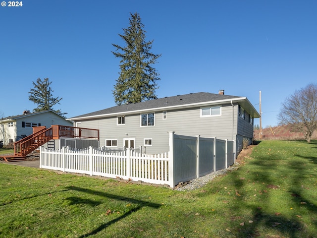 rear view of house with a yard and a wooden deck