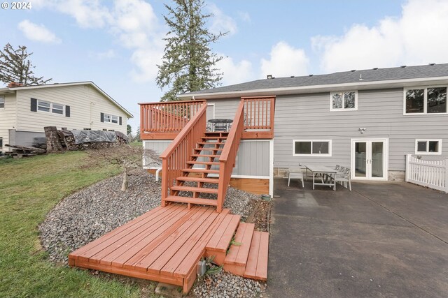 back of house featuring a lawn, a patio area, french doors, and a wooden deck