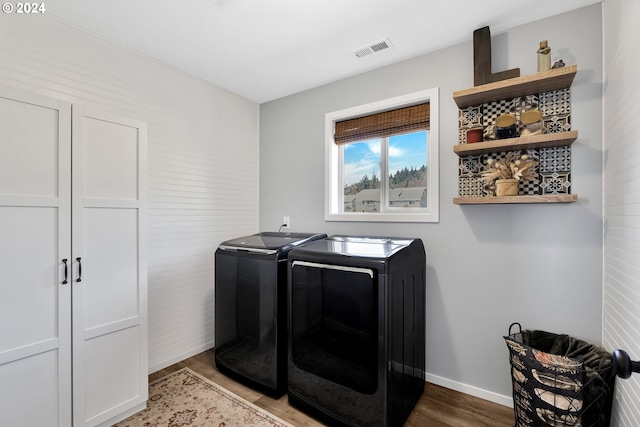 laundry area with washer and dryer and wood-type flooring