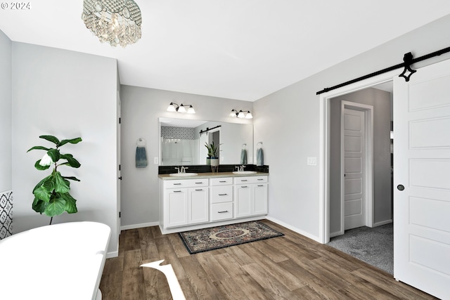 bathroom featuring plus walk in shower, vanity, hardwood / wood-style flooring, and a notable chandelier