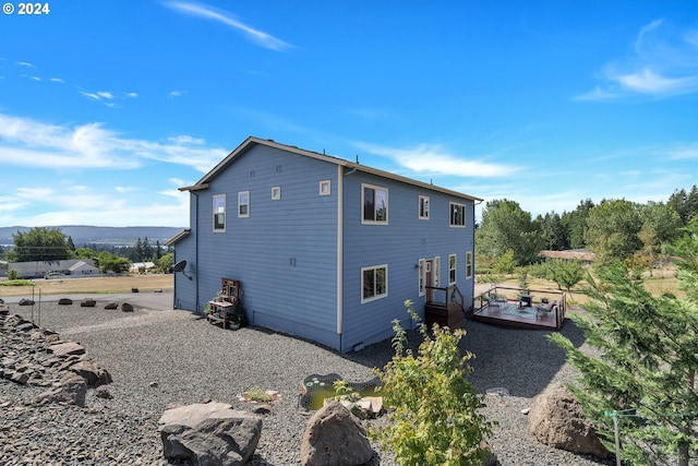 rear view of property featuring a deck with mountain view