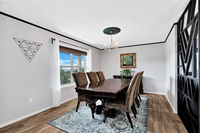 dining space featuring wood-type flooring, crown molding, and a chandelier