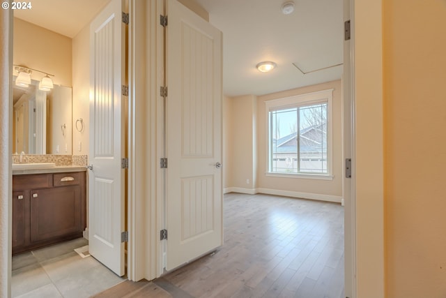 corridor with sink and light hardwood / wood-style floors