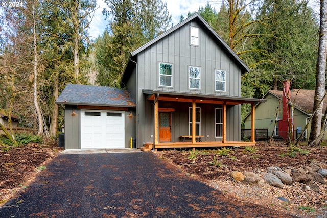 view of front of property with a garage, central AC, and covered porch