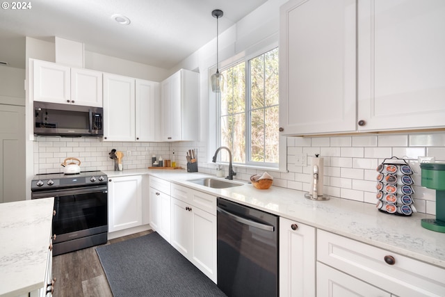 kitchen with appliances with stainless steel finishes, white cabinets, sink, tasteful backsplash, and dark wood-type flooring