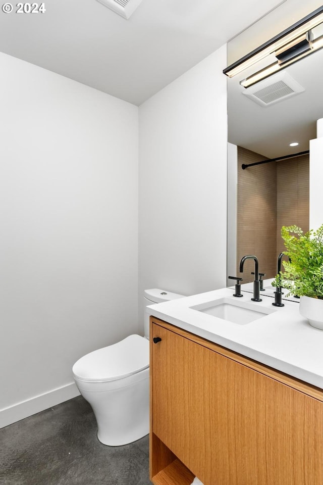 bathroom with vanity, concrete flooring, and toilet