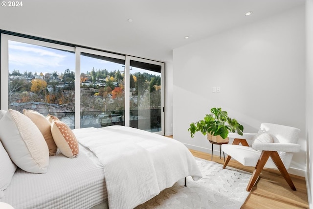 bedroom with access to exterior and wood-type flooring