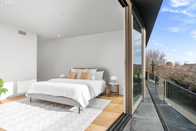 bedroom with wood-type flooring and access to outside