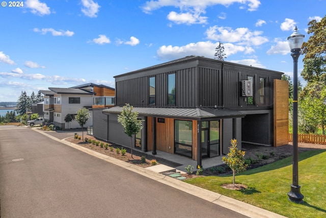 contemporary home featuring a balcony and a front lawn