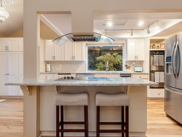 kitchen with white cabinets, a center island, and a kitchen bar