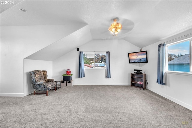 unfurnished room with carpet, vaulted ceiling, and a textured ceiling