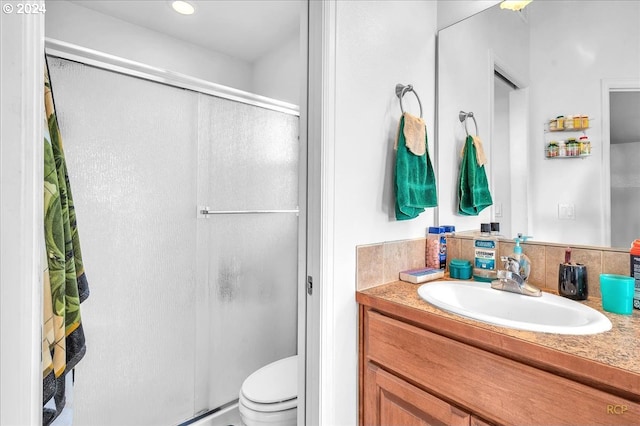 bathroom with vanity, an enclosed shower, toilet, and backsplash