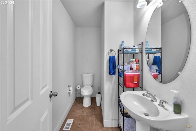 bathroom featuring toilet, sink, and tile patterned floors