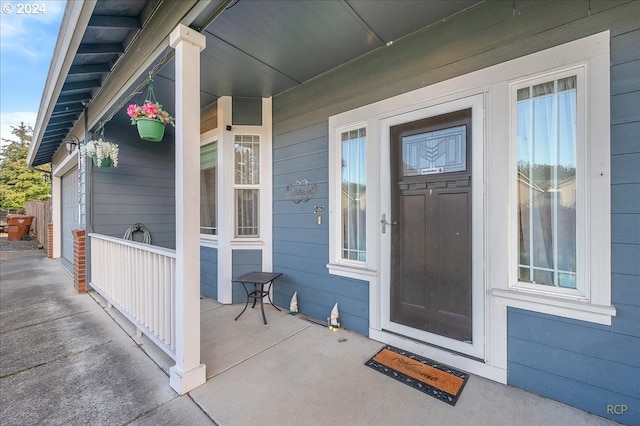 property entrance featuring covered porch and a garage