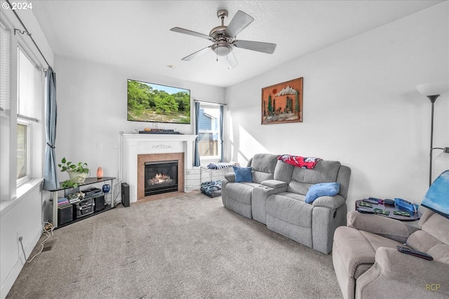 carpeted living room with a fireplace and ceiling fan