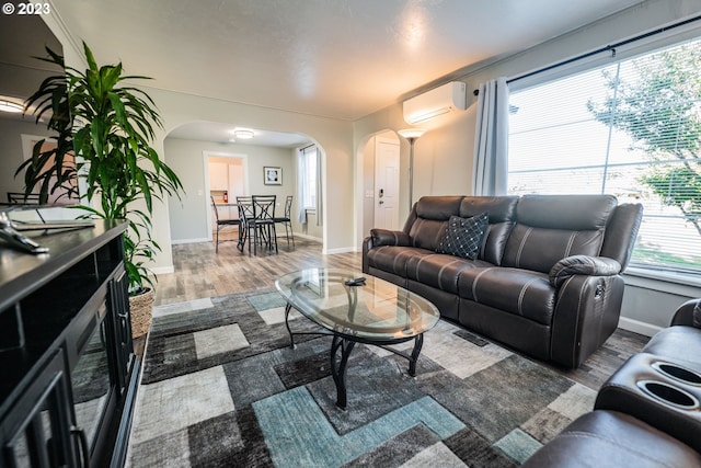 living room with hardwood / wood-style flooring and an AC wall unit