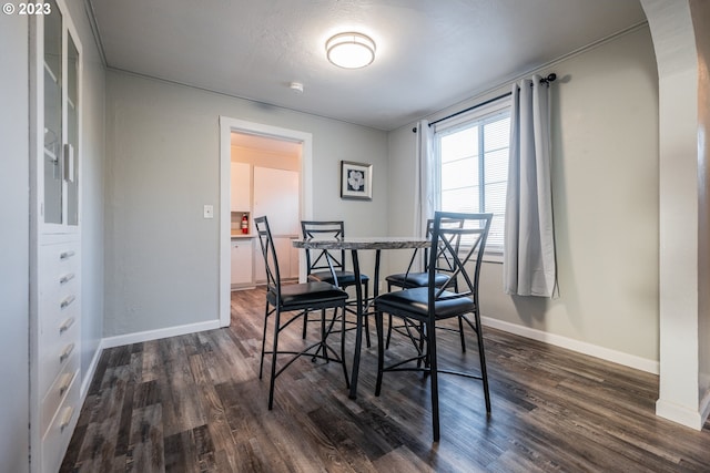 dining area with a textured ceiling and dark hardwood / wood-style flooring