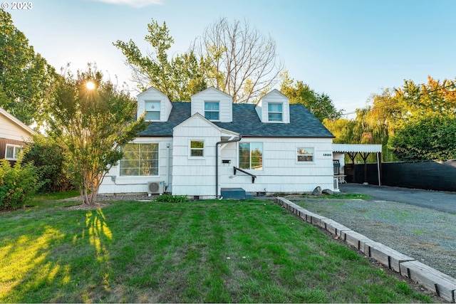 rear view of property featuring a carport and a lawn