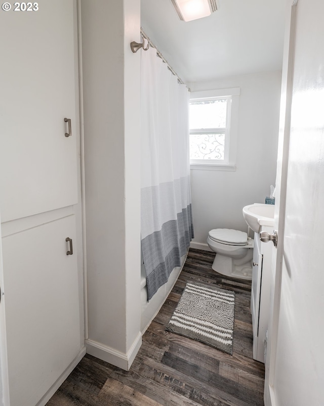 bathroom with vanity, curtained shower, hardwood / wood-style flooring, and toilet