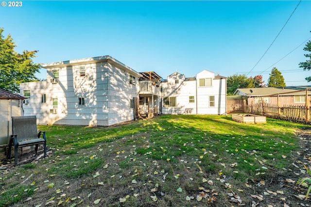 back of property with a yard and a balcony