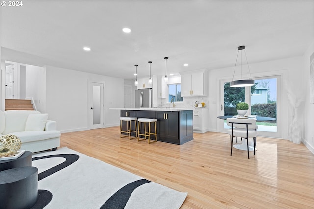 living room with sink and light hardwood / wood-style floors