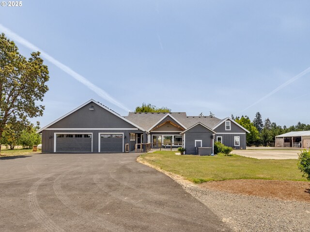 21625 Butteville Rd, Aurora, OR 97002 - craftsman-style home with a garage, board and batten siding, asphalt driveway, covered porch, and a front yard