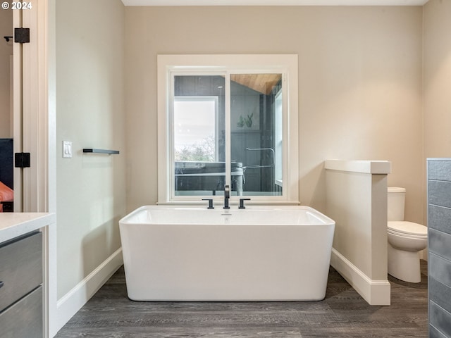 bathroom featuring hardwood / wood-style flooring, a bathtub, toilet, and vanity