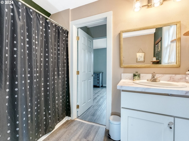 bathroom with hardwood / wood-style flooring, sink, and a shower with shower curtain