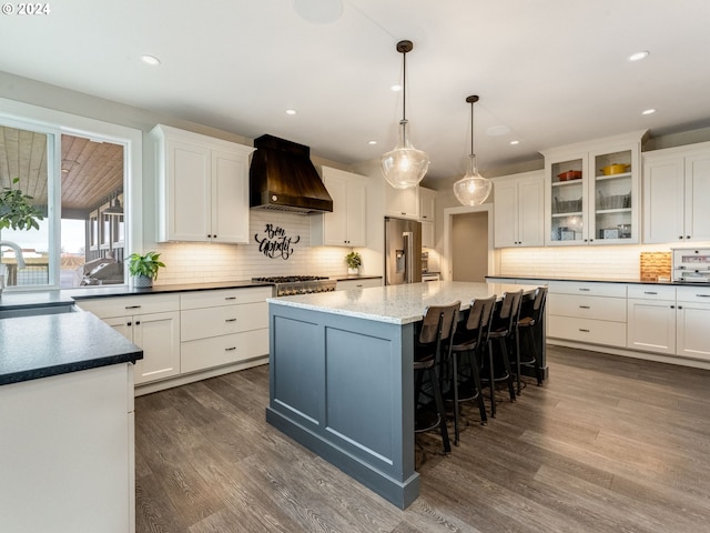 kitchen featuring a kitchen island, dark hardwood / wood-style flooring, custom range hood, and white cabinetry