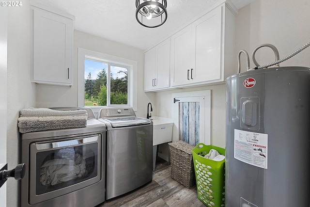 washroom with hardwood / wood-style floors, cabinets, electric water heater, sink, and washer and dryer