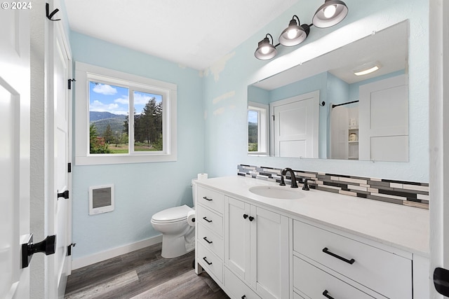 bathroom with decorative backsplash, vanity, hardwood / wood-style flooring, and toilet