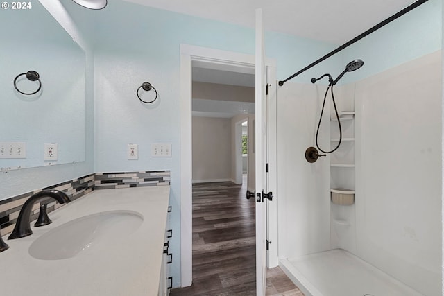 bathroom featuring walk in shower, vanity, and hardwood / wood-style flooring