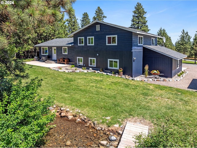 back of property with a patio area and a yard