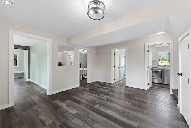 unfurnished living room with a textured ceiling, separate washer and dryer, and dark hardwood / wood-style floors