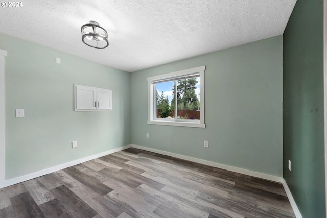 empty room with a textured ceiling and hardwood / wood-style flooring