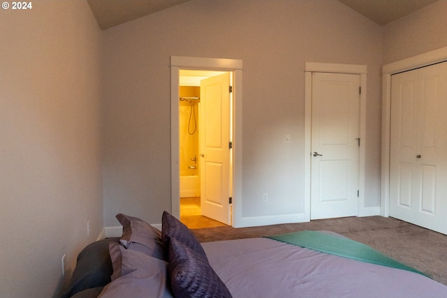 carpeted bedroom with a closet and vaulted ceiling