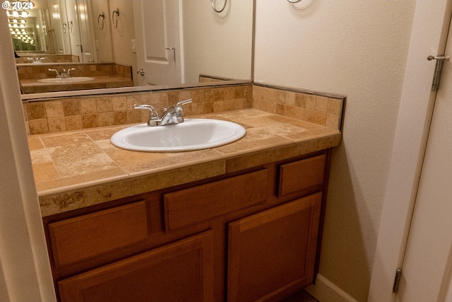 bathroom with vanity and tasteful backsplash