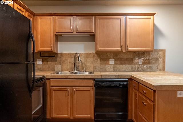 kitchen featuring black appliances, decorative backsplash, sink, and tile countertops