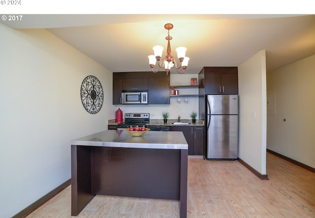 kitchen featuring dark brown cabinetry, sink, hanging light fixtures, appliances with stainless steel finishes, and a notable chandelier