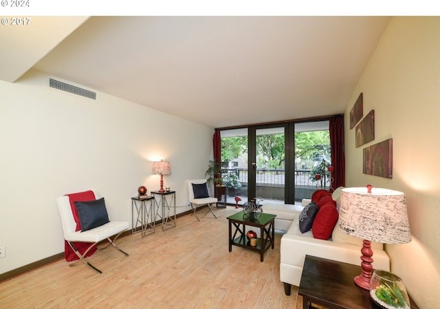 living room featuring floor to ceiling windows and light wood-type flooring