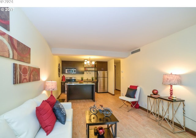 living room featuring a notable chandelier and light hardwood / wood-style flooring