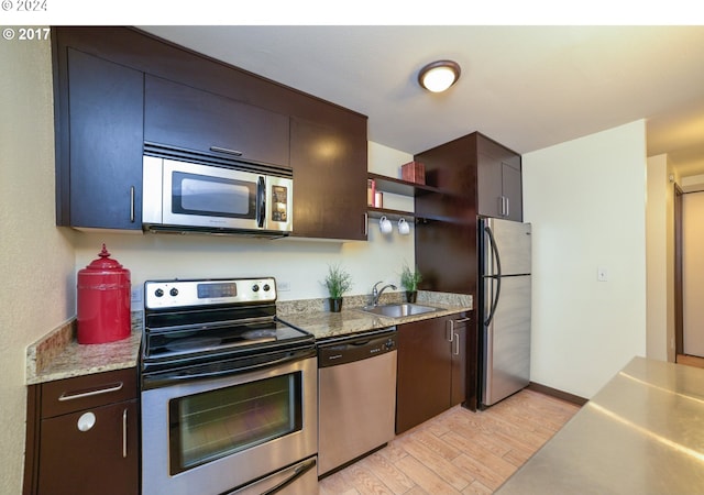 kitchen featuring stainless steel appliances, sink, and light hardwood / wood-style flooring