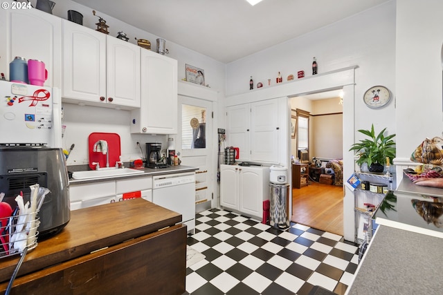 kitchen featuring white dishwasher, sink, white cabinets, and dark wood-type flooring