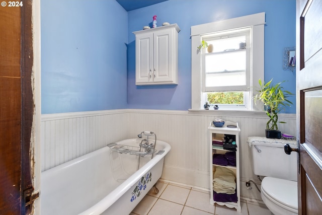 bathroom featuring a bathing tub, toilet, and tile patterned flooring