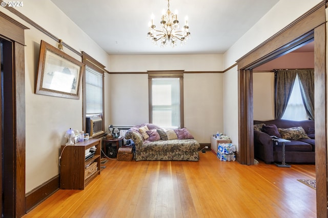 sitting room with hardwood / wood-style floors and a notable chandelier