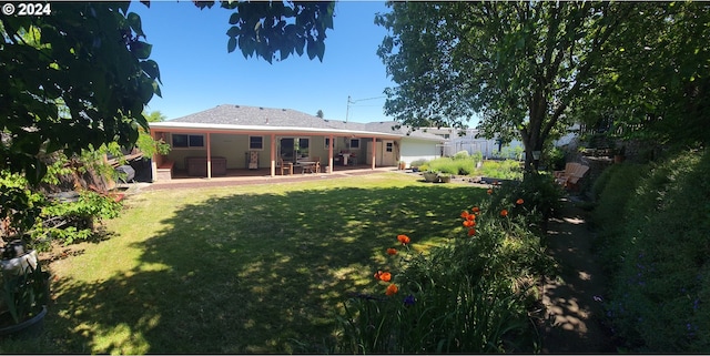 rear view of house with a lawn and a patio area