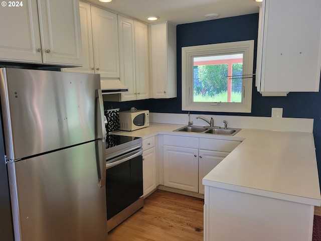 kitchen with sink, appliances with stainless steel finishes, light hardwood / wood-style floors, custom range hood, and white cabinets